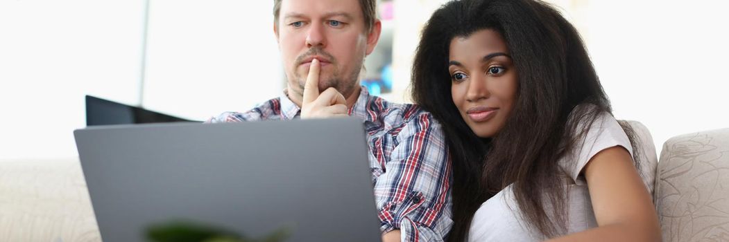 Portrait of middle aged man and latino american woman watch impressive film online. Couple think on story change. Leisure, movie day, lazy weekend concept