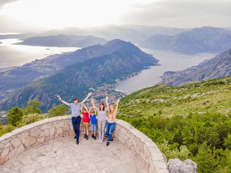 happy friends enjoys the view of Kotor. Montenegro. Bay of Kotor, Gulf of Kotor, Boka Kotorska and walled old city. Travel to Montenegro concept. Fortifications of Kotor is on UNESCO World Heritage.