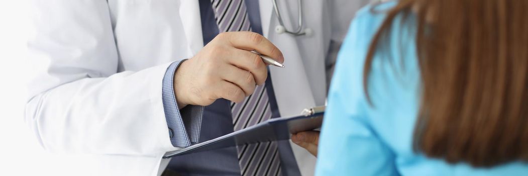 Close-up of man doctor in uniform and stethoscope consult woman patient. Client listen to instructions of professional specialist. Hospital, health concept