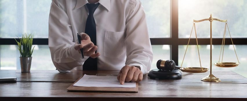 Young lawyer business man working with paperwork on his desk in office workplace for consultant lawyer concept of photography vintage tone with sunlight effect..