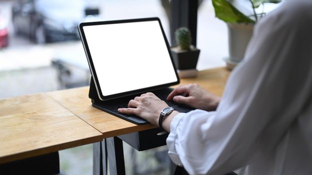 Close up businesswoman sitting in cafe and using computer tablet.