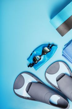 Sports equipment for swimming in the pool and open water on a blue background, close-up