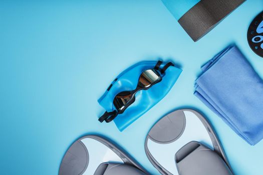 Sports equipment for swimming in the pool and open water on a blue background