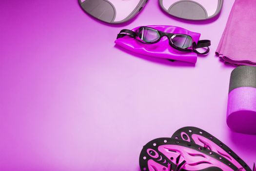 A set for swimming training in open water and in the pool on a pink background