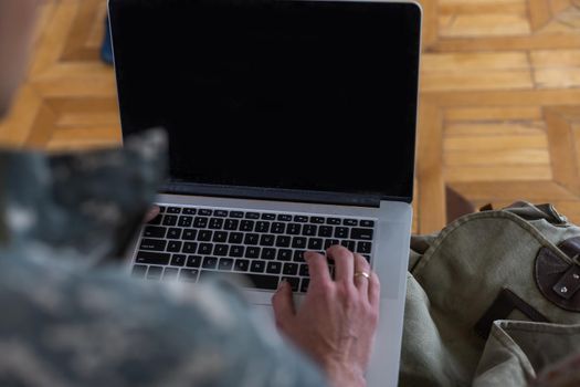 soldier in military uniform using high tech computer in headquarters intelligence center. Focus on laptop display.