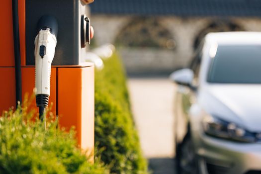 Charge station for electric cars. Electric car charger. Alternative energy for ecological cars. Electric, zero pollution cars on green energy concept on modern city parking lot.