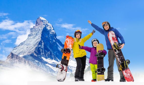 family and snowboard on snowy mountain.