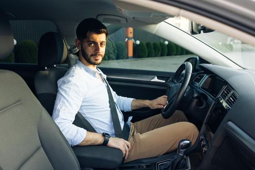 Protection of a person in vehicles. Fasten your body with a seat belt in the car. Bearded man fastens car seat belt with hand. Compliance with safety rules for driving. Road safety regulations concept