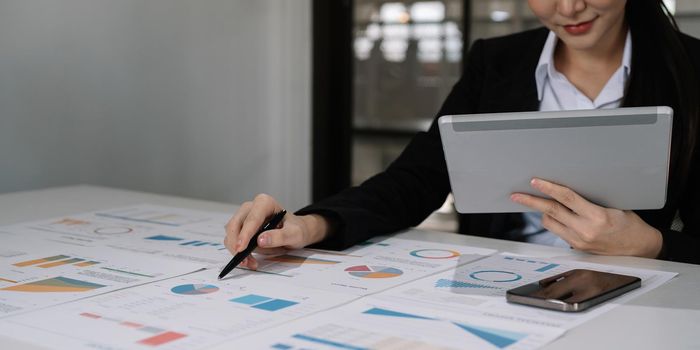 Business asian woman analyse and discuss and brainstorming the financial report chart data in office Financial advisor teamwork and accounting concept