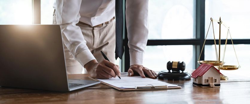 Close up young businessman standing near table with pen in hands, ready signing profitable offer agreement after checking contract terms of conditions, executive manager involved in legal paperwork