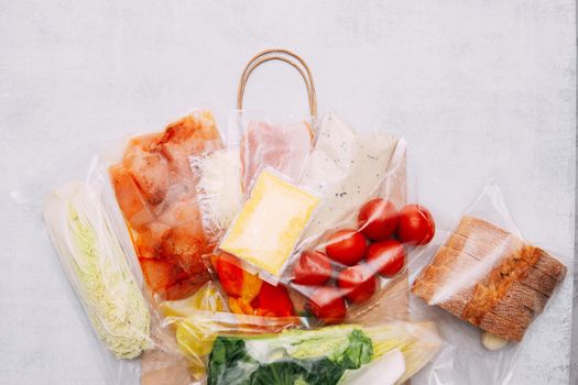 Salad dinner set: chicken, lettuce, tomatoes, peking cabbage, cheese, bacon, bread, olive oil sauces and spices. A set for delivering food for dinner on a white background. I cook at home. Preparing Caesar salad.