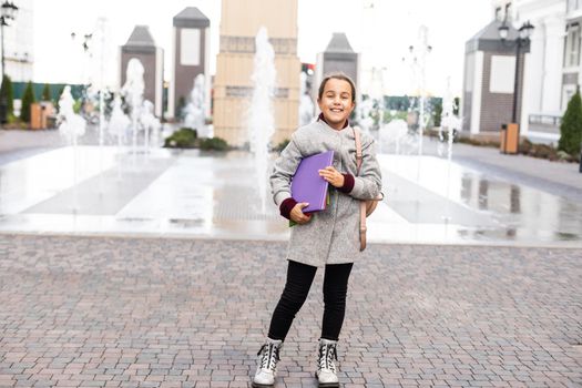 Beautiful little schoolgirl with a backpack.