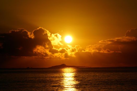 Sunrises over Kaohikaipu (Black/Turtle) Islands with sunlight reflecting on the ocean water of Waimanalo bay on Oahu, Hawaii.