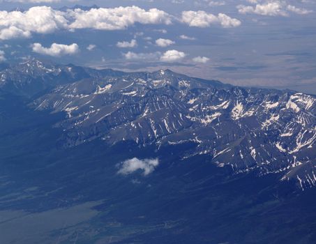 Aerial view of Colorado's Rocky Mountains during the summer with a small amount of snow still left on the mountains.                               