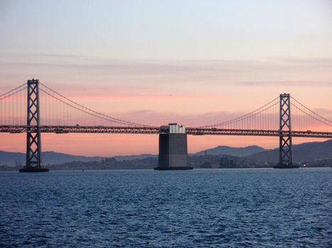 Center of San Francisco Bay Bridge at Dusk with city in the background.