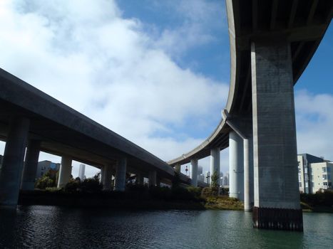 Overhead Highways intersect in the air as they go into the city of San Francisco as they hang over Mission Creek on a nice day in California. 