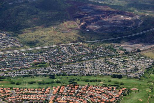 Aerial of Highway,  Kapolei homes, golf course, and quarry on the west side Oahu, Hawaii on a beautiful day.                               