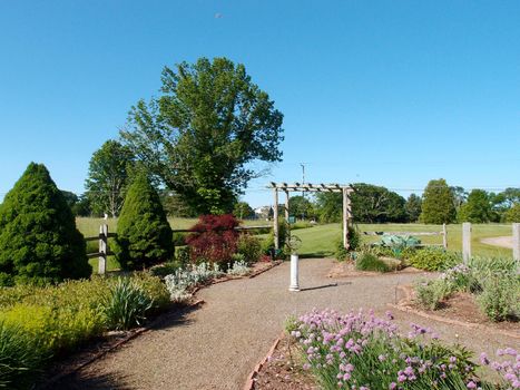 Path in Garden with orb statue in center and archway in Lebanon,  Connecticut. USA