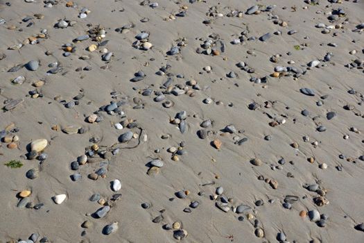 Pebble rocks in the sand.  Background, texture.