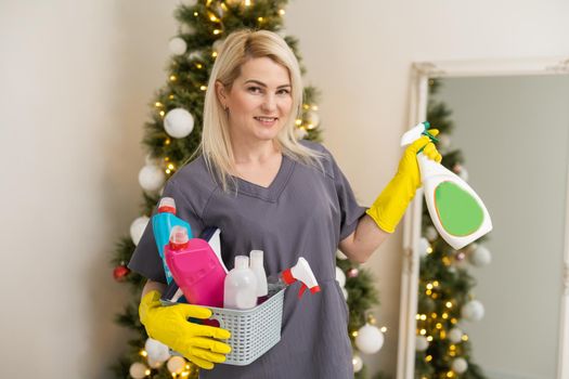 Portrait of attractive young woman wiping table before Christmas celebration