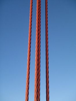 A close up  shot of a suspension cable on the Golden Gate Bridge against blue sky.