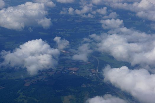 aerial photograph of rural Eastern USA with clouds, fields, river, houses, and roads