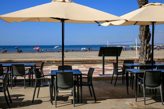 Santa Pola, Alicante, Spain- June 30, 2022: Beach bar Restaurant with empty terrace on Levante beach on a sunny day
