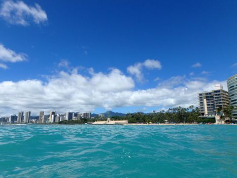 Historic Natatorium, Waikiki, Condomiums, Honolulu cityscape and San Souci Beach, coconut trees and lifeguard tower on a nice day Oahu, Hawaii seen from the water.  