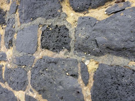 Close-up of a old Cemented lava stone wall with small shells on the Oahu, Hawaii.