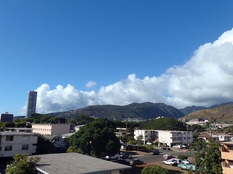 Kapahulu town in Honolulu with homes, condos, and mountains of Tantalus and St. Louis Heights on a clear day on Oahu, Hawaii