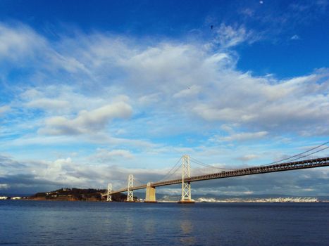 San Francisco side of Bay Bridge going into Yerba Buena island with Oakland visible in the distance