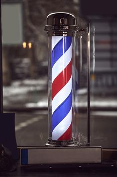 The Barber Shop. The famous symbol of a barber shop with it swirling red, blue and white stripes.