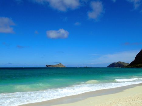 Gentle wave lap on Waimanalo Beach looking towards Rabbit island and Rock island on a nice day Oahu, Hawaii.  September 2014