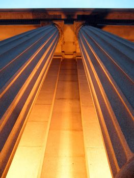 Looking upwards at Columns light up with Orange light at Dusk in San Francisco, California.