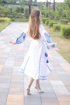 ukrainian blonde girl in national blue dress - embroidered shirt. young woman patriot. outdoors photo of charming female.