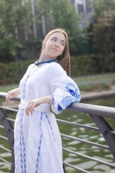 ukrainian blonde girl in national blue dress - embroidered shirt. young woman patriot. outdoors photo of charming female.