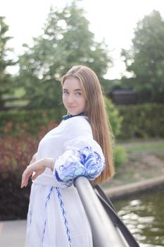 ukrainian blonde girl in national blue dress - embroidered shirt. young woman patriot. outdoors photo of charming female.