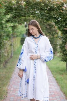 ukrainian blonde girl in national blue dress - embroidered shirt. young woman patriot. outdoors photo of charming female.