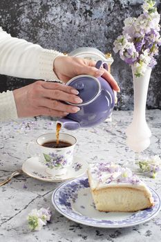 still life with black tea and cheese cake, spring bouquet of delicate lilac flowers. High quality photo