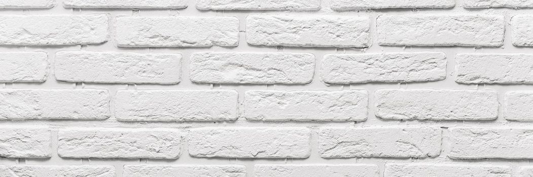 long white brick wall. The texture of the old brick painted with white paint. Web banner.