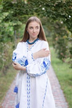 ukrainian blonde girl in national blue dress - embroidered shirt. young woman patriot. outdoors photo of charming female.