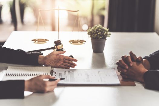 Business woman and lawyers discussing contract papers with brass scale on wooden desk in office. Law, legal services, advice, Justice concept