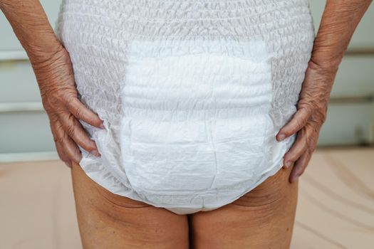 Asian elder senior woman patient wearing adult incontinence diaper pad in hospital.