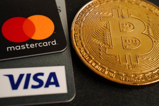 Bangkok, Thailand - December 15, 2021 Golden bitcoin with credit card on US dollar banknotes money for business and commercial, Digital currency, Virtual cryptocurrency.