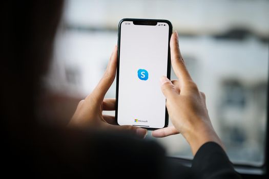 CHIANG MAI, THAILAND - April 06 ,2021: Woman holding iphone with skype apps. Skype is part of Microsoft, can make video, audio calls, chat messages and do much more using Skype..