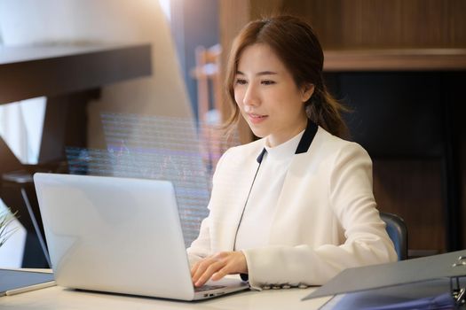 Business woman using computer to trade charts to find buy and sell points for her port.