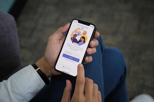 Chiangmai, Thailand - April 06, 2021: A user opens the Microsoft Teams mobile app. Teams is a unified team communication and collaboration platform with workplace chat, video meetings, and file storage.
