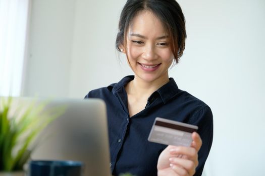 Online payment, Young Women's hands holding credit card and using computer for online shopping at home