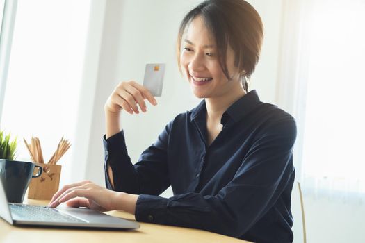 Online payment, Young Women's using computer and hands holding credit card for online shopping