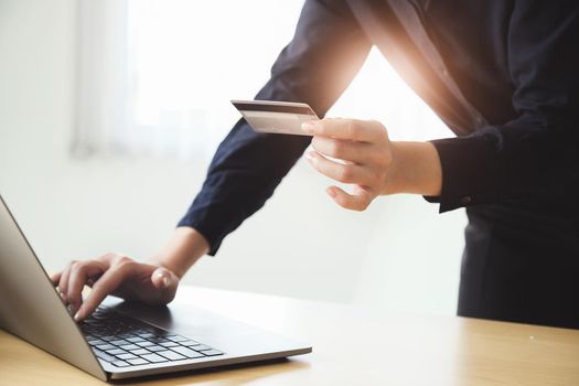 Online payment, Young Women's hands holding credit card and using computer for online shopping at home